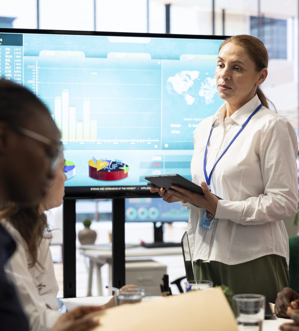 Teammates assembling in a boardroom to go over their analysis results after examining graphic representations and feedback from stakeholders. Staff and team leader exchange new ideas.
